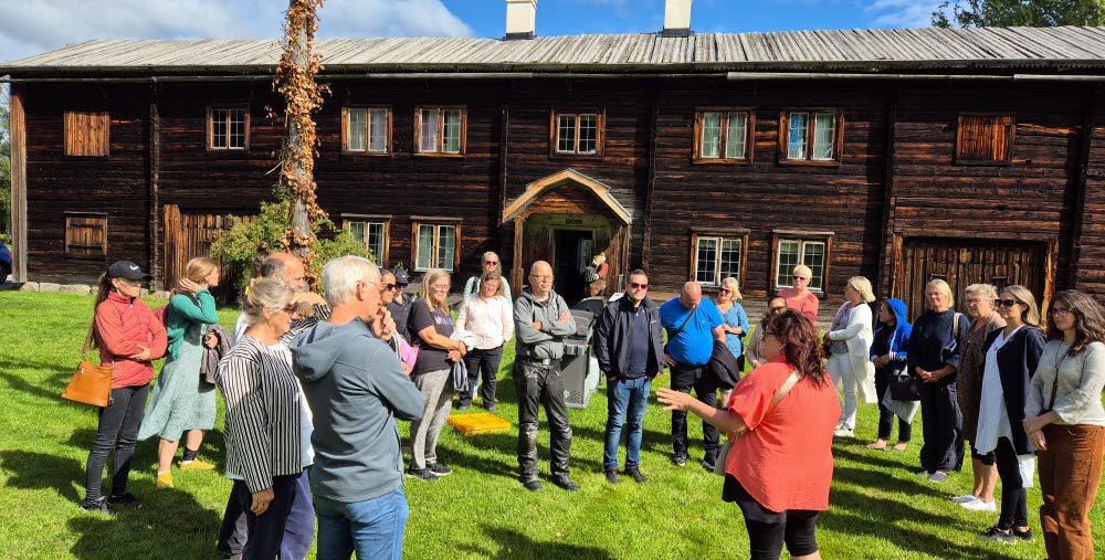 Gruppbild på människor vid en Hälsingegård