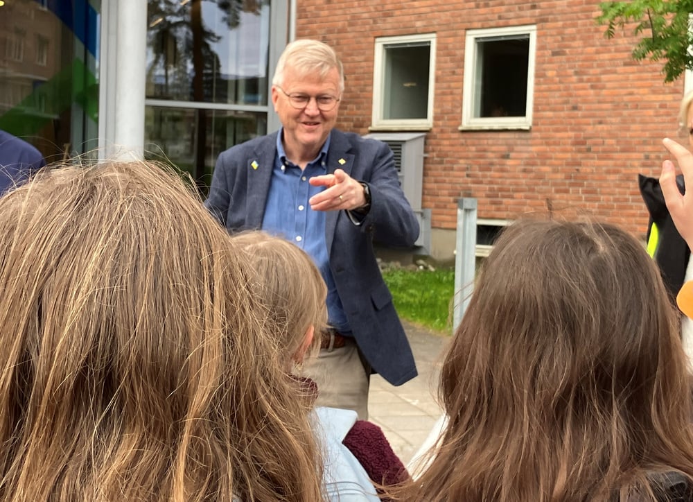 En man står framför en grupp barn.