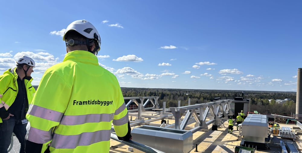 Byggprojektledaren inspekterar bygget av den nya helikopterplattan på taket av hus 60 på Gävle sjukhus. I bakgrunden syns Magnus Busk, programchef för Framtidsbygget. 