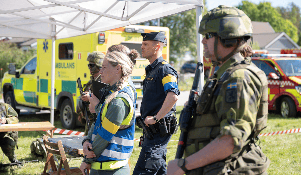 En grupp människor som står i gräset.