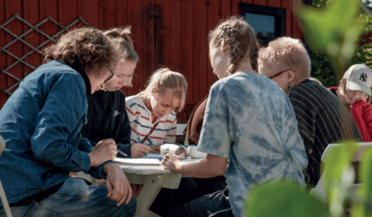 En grupp människor som sitter runt ett bord.