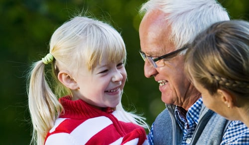 En äldre man och en ung flicka som håller i en golfklubba.