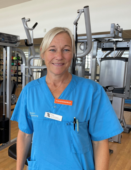 En kvinna i operationskl&auml;der som st&aring;r i ett gym.