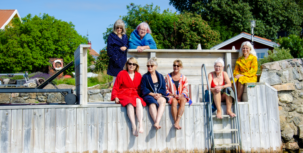 7 personer sitter på en brygga i solen