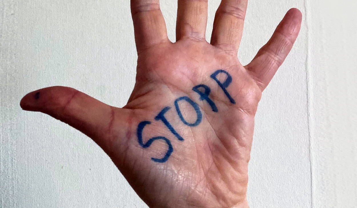 Uppräckt hand med texten "Stopp"